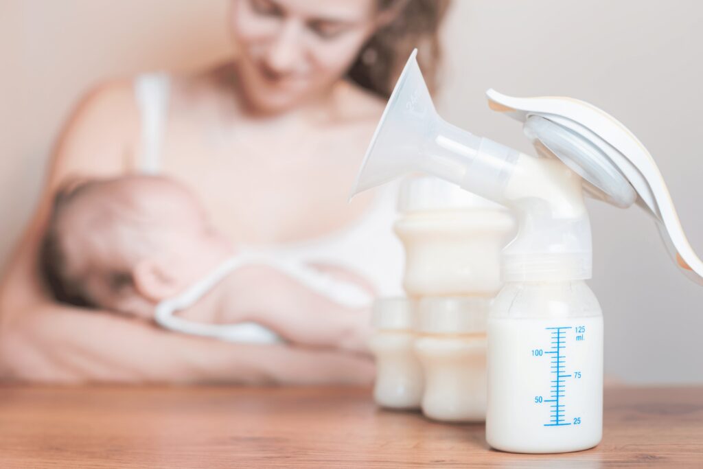 mom breastfeeding with bottles of expressed breast milk