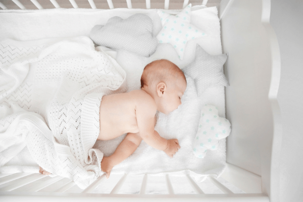 baby sleeping in a bedside bassinet